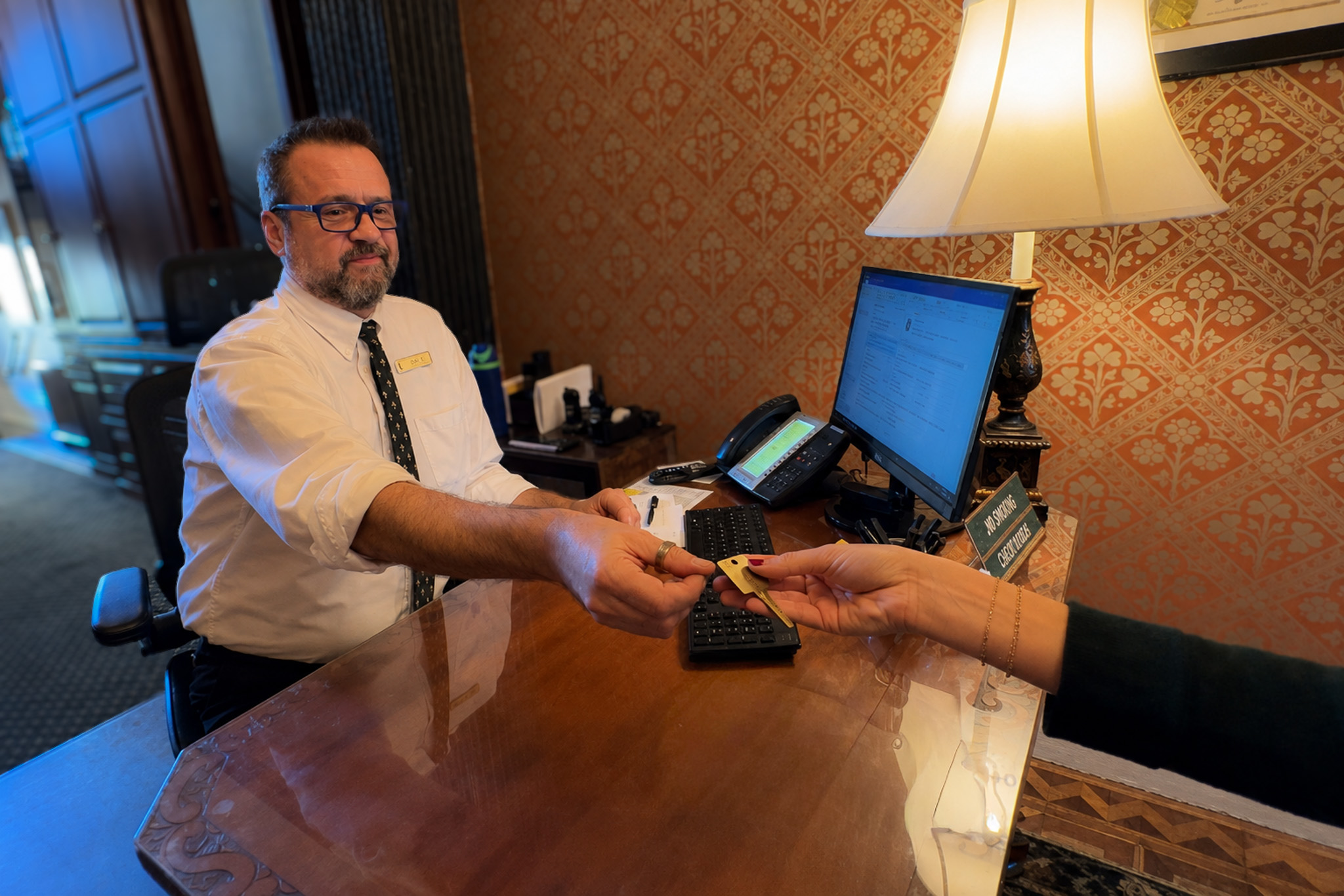 Front Desk concierge handing key to guest